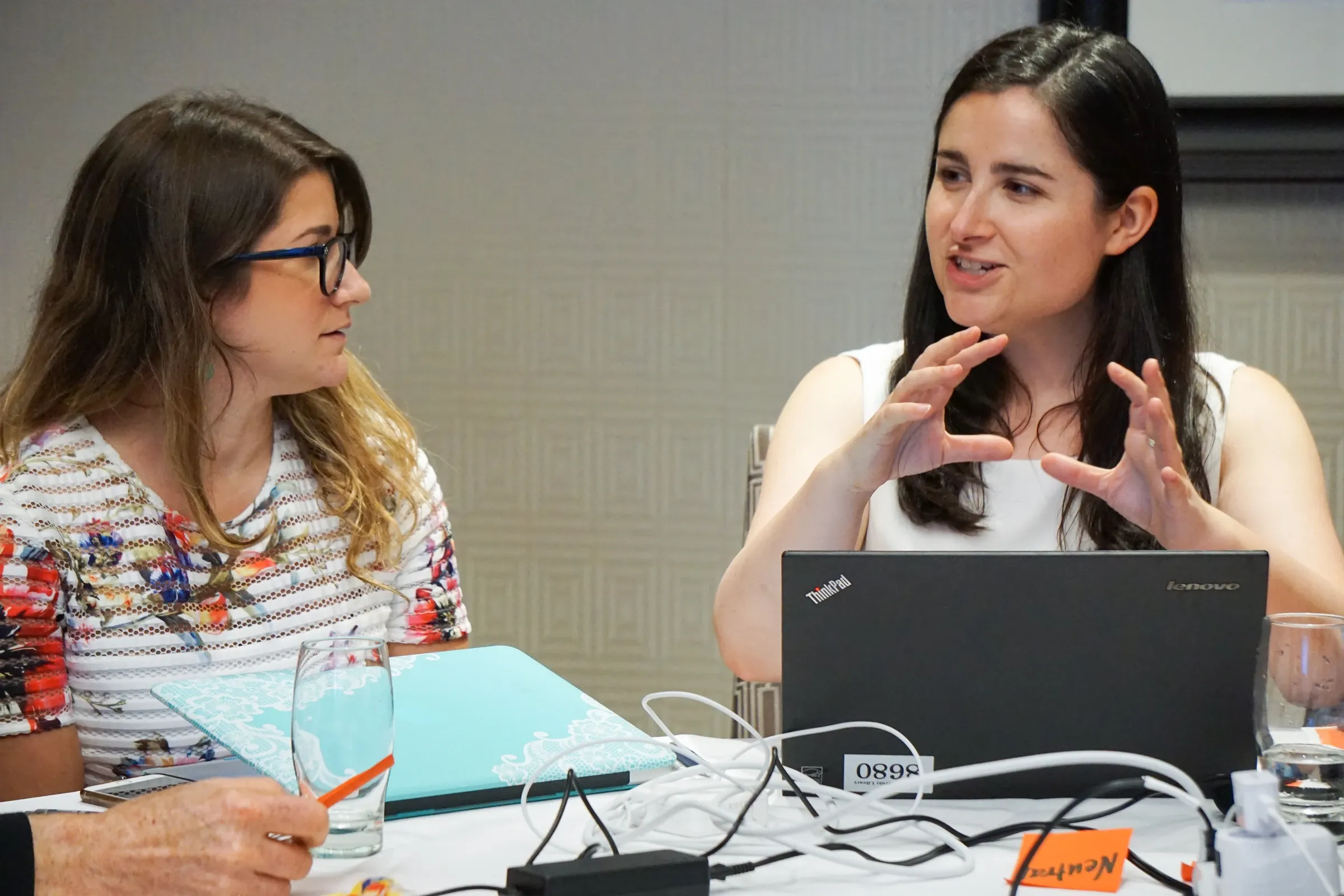 Two women discussing ideas during a professional workshop session.